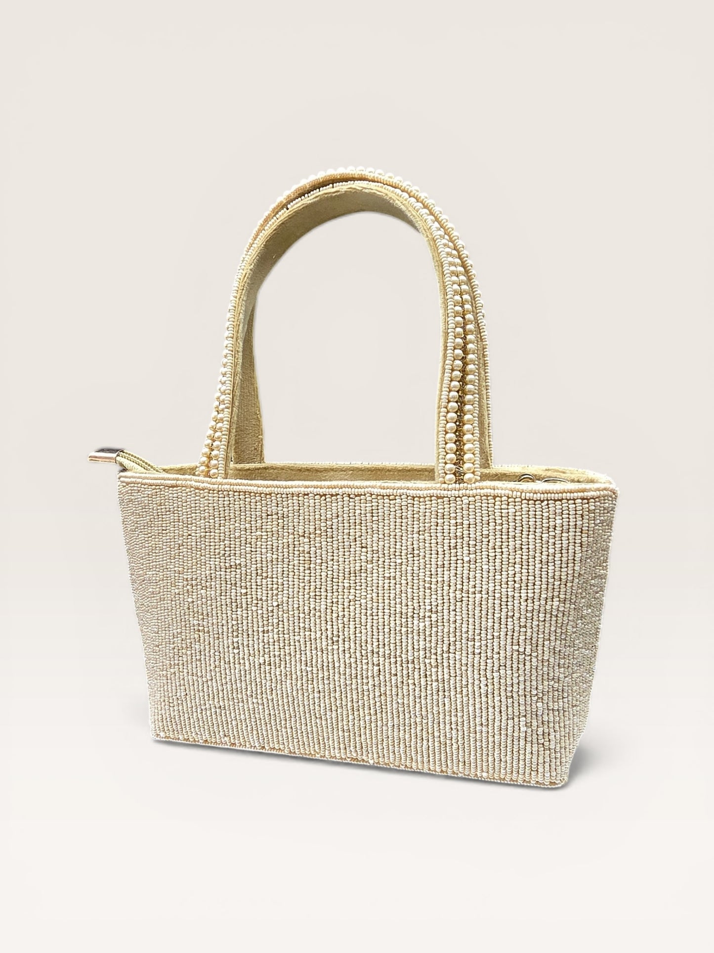 Hand-embroidered bucket bag with colorful floral beadwork and twin handles on a velvet base.