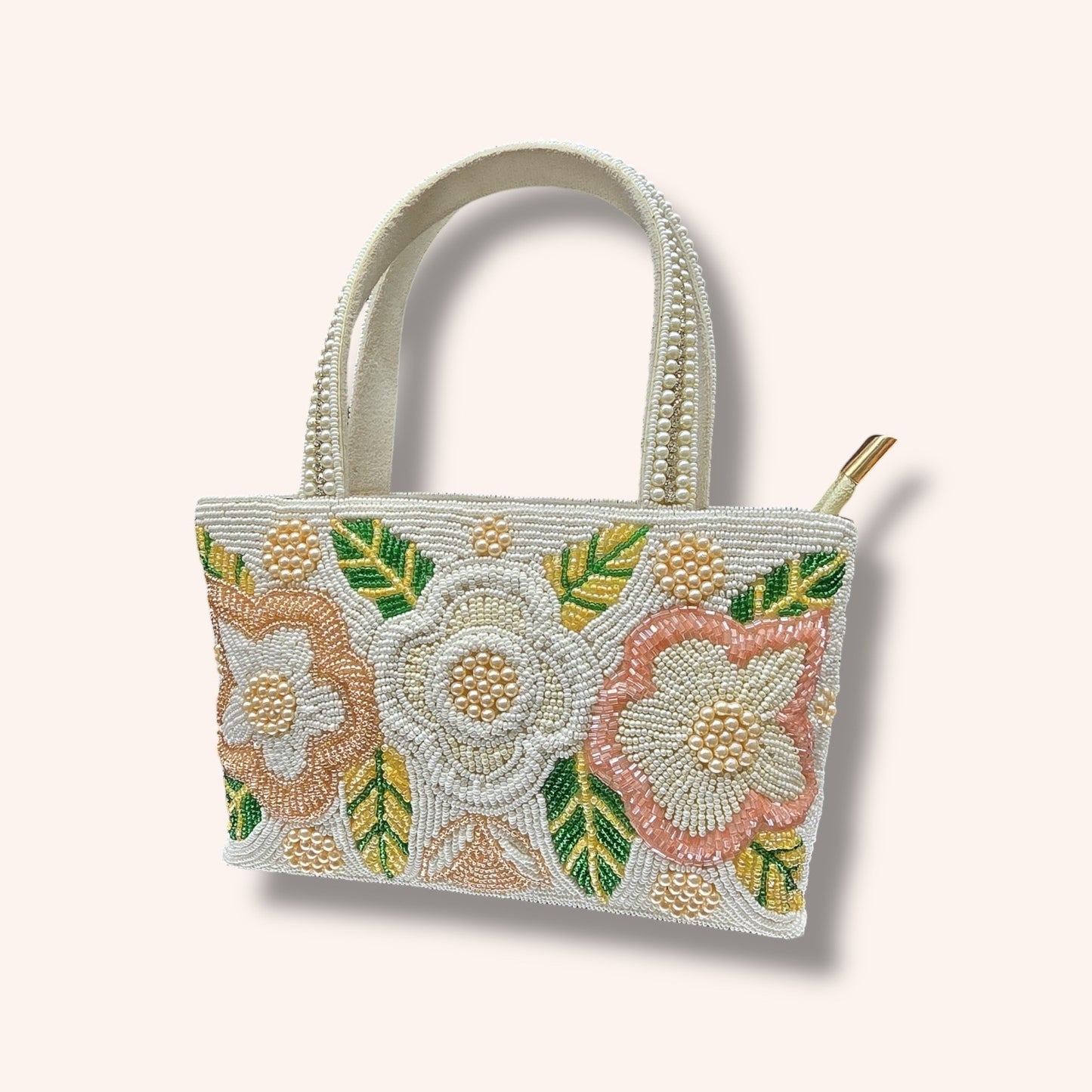 Hand-embroidered bucket bag with colorful floral beadwork and twin handles on a velvet base.