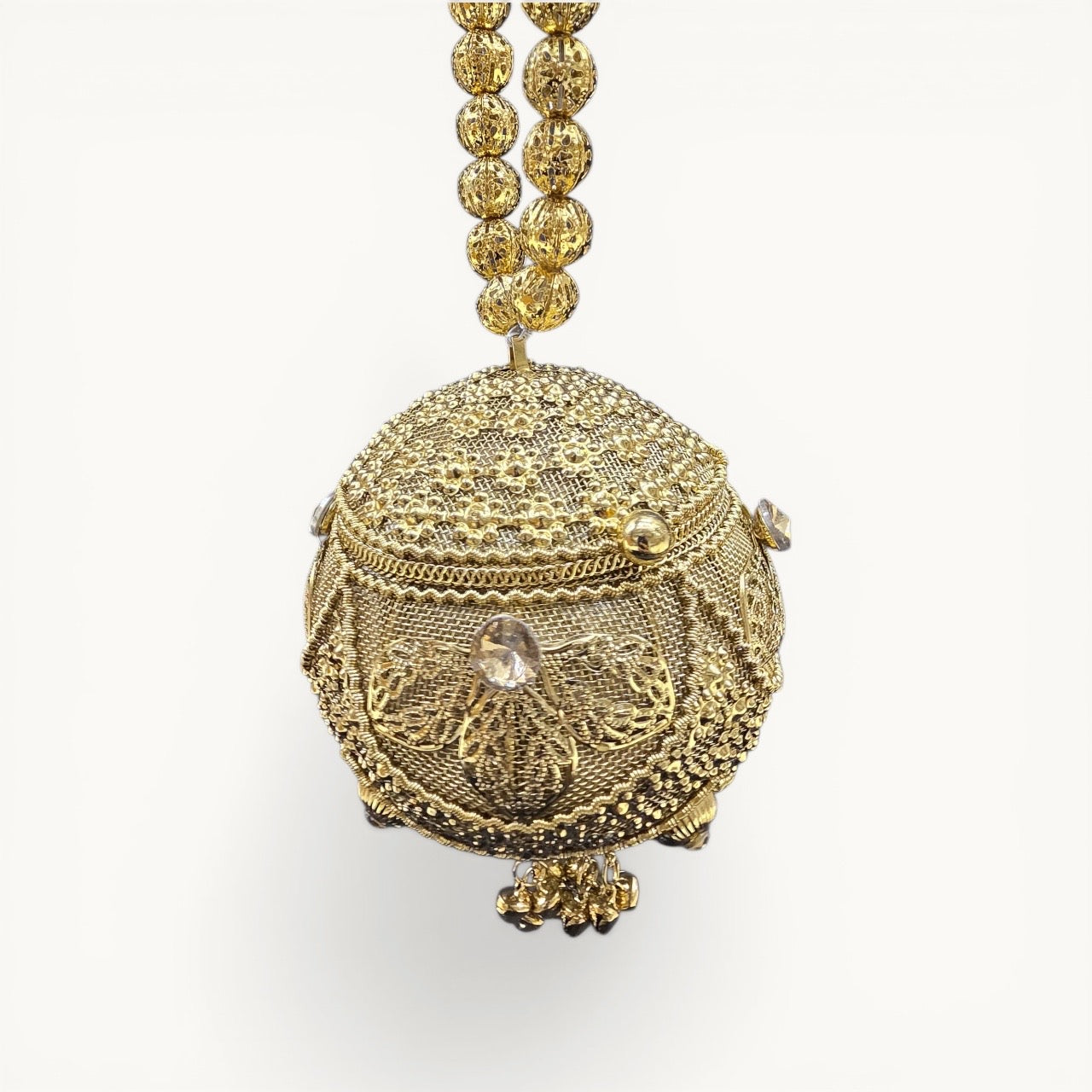 Handcrafted coconut-shaped brass mini clutch with gold filigree and beaded wristlet handle.