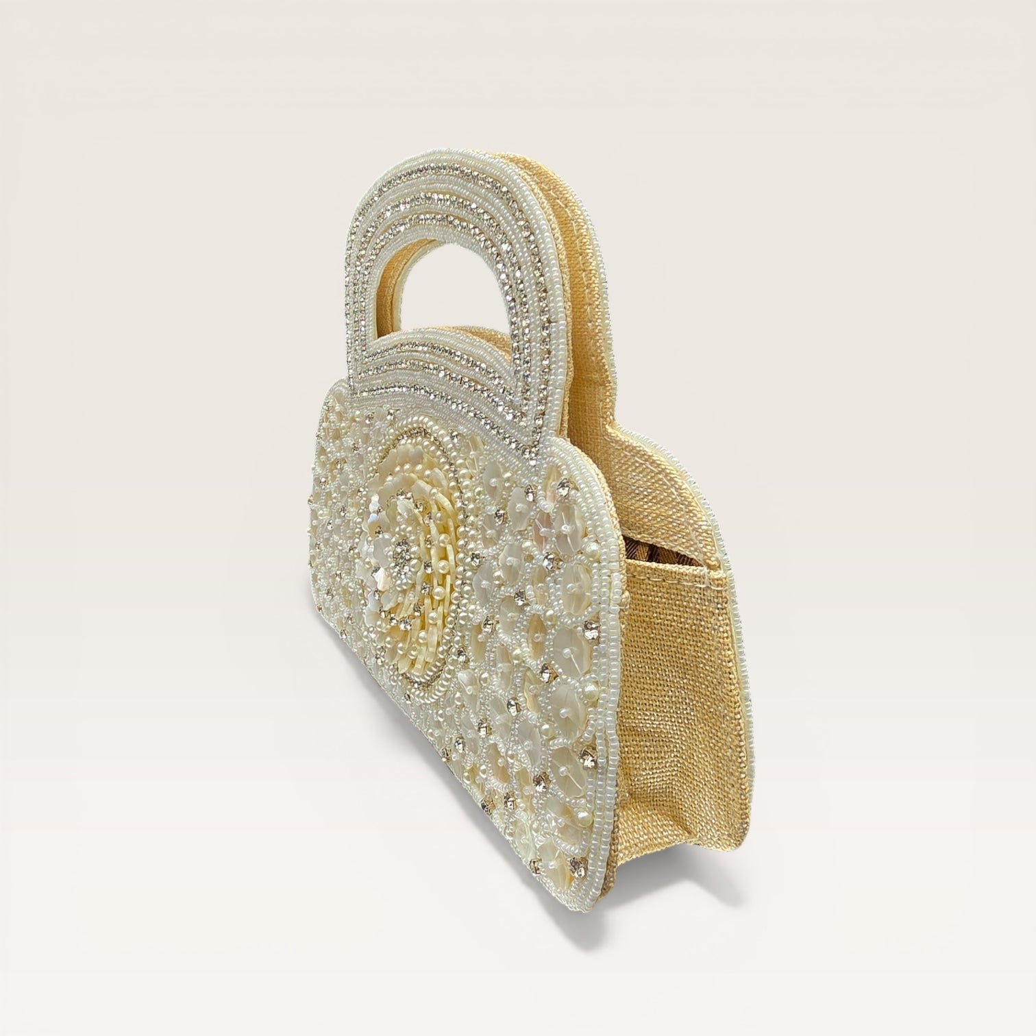 Dual-sided hand-embroidered luxury wedding bag featuring a central mother-of-pearl floral motif and a geometric pearl pattern on a natural jute base. This mini bucket-style bridal clutch includes a secure zip closure and an integrated hand-beaded handle, perfect for ethnic and festive wear