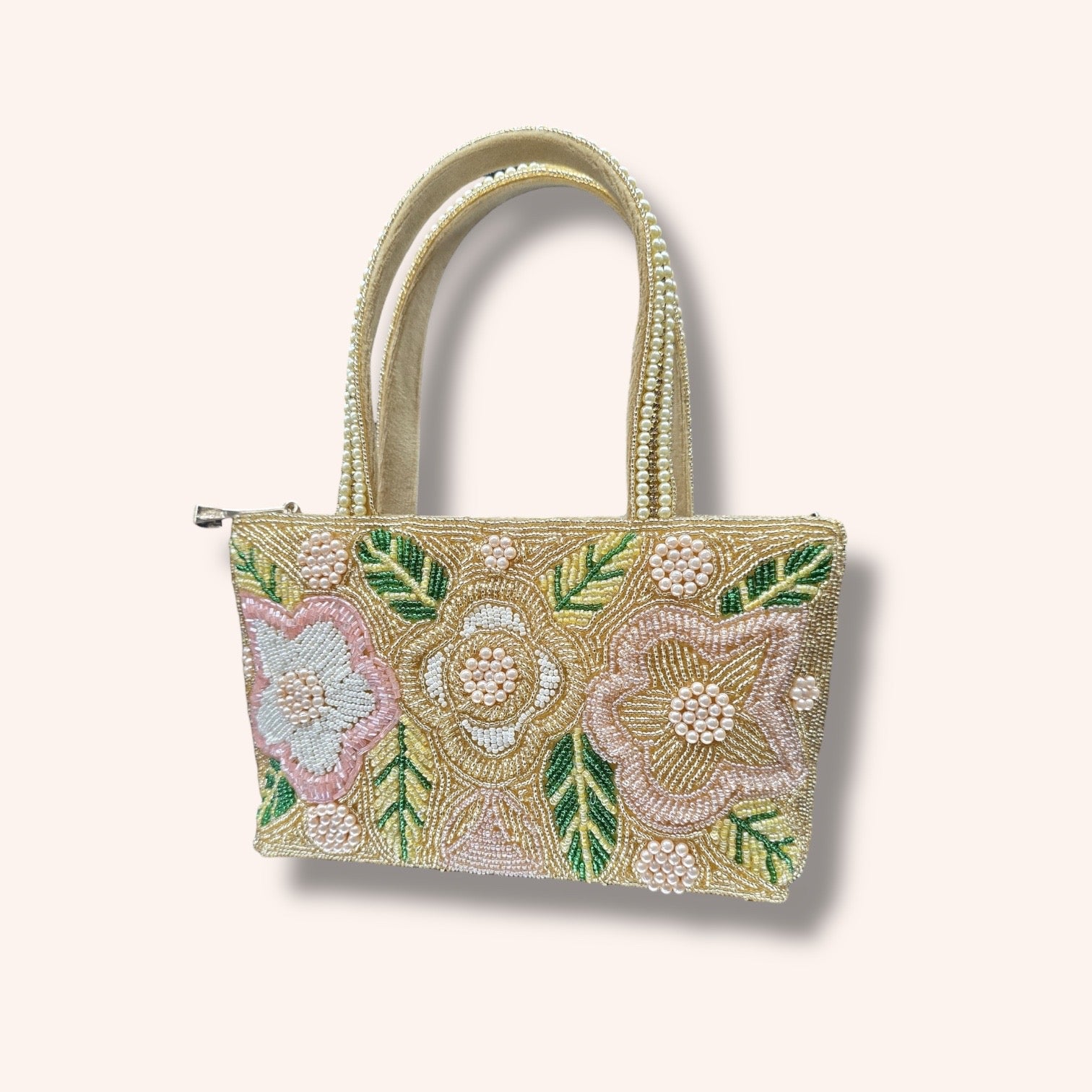 Hand-embroidered bucket bag with colorful floral beadwork and twin handles on a velvet base.