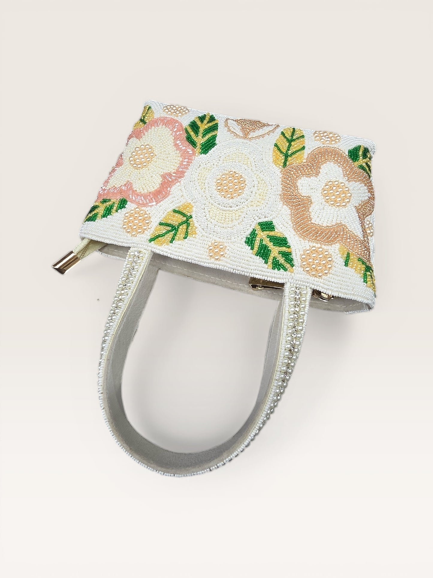 Hand-embroidered bucket bag with colorful floral beadwork and twin handles on a velvet base.