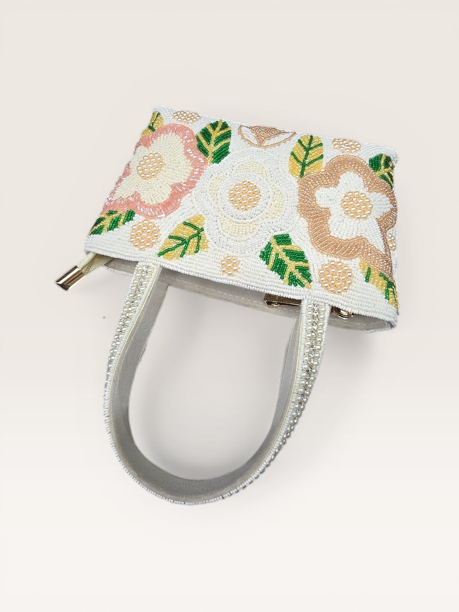 Hand-embroidered bucket bag with colorful floral beadwork and twin handles on a velvet base.