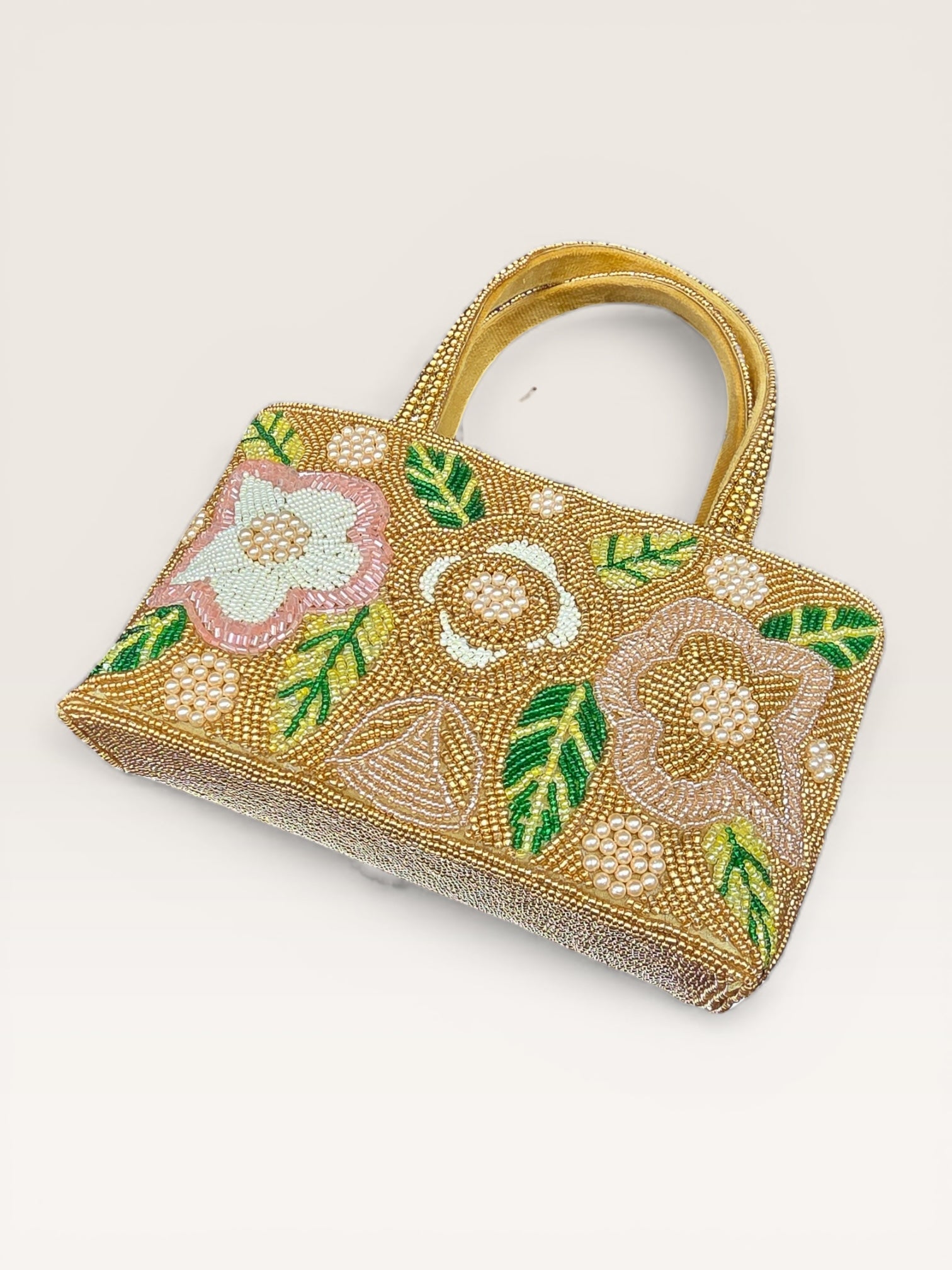 Hand-embroidered bucket bag with colorful floral beadwork and twin handles on a velvet base.