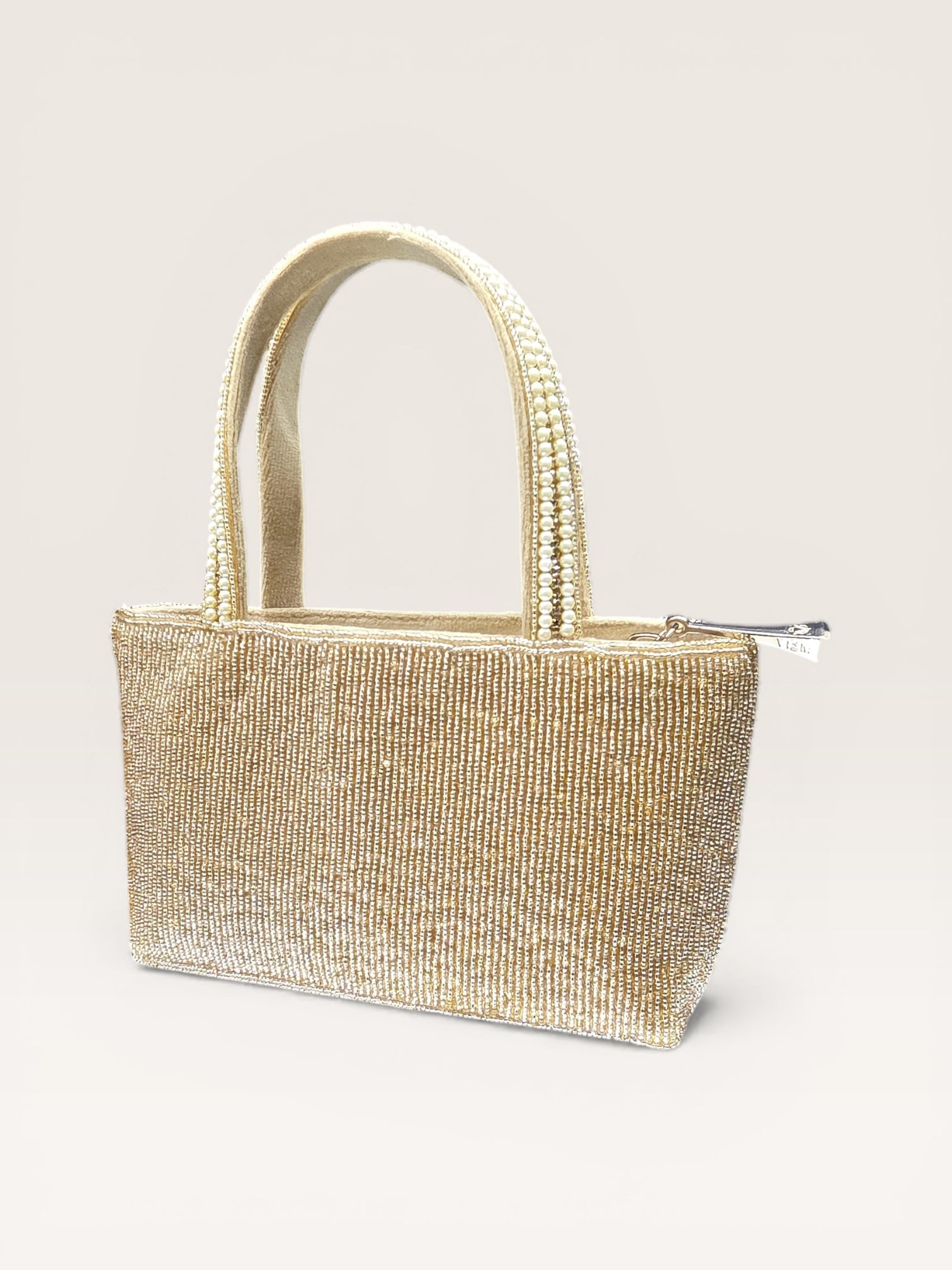 Hand-embroidered bucket bag with colorful floral beadwork and twin handles on a velvet base.