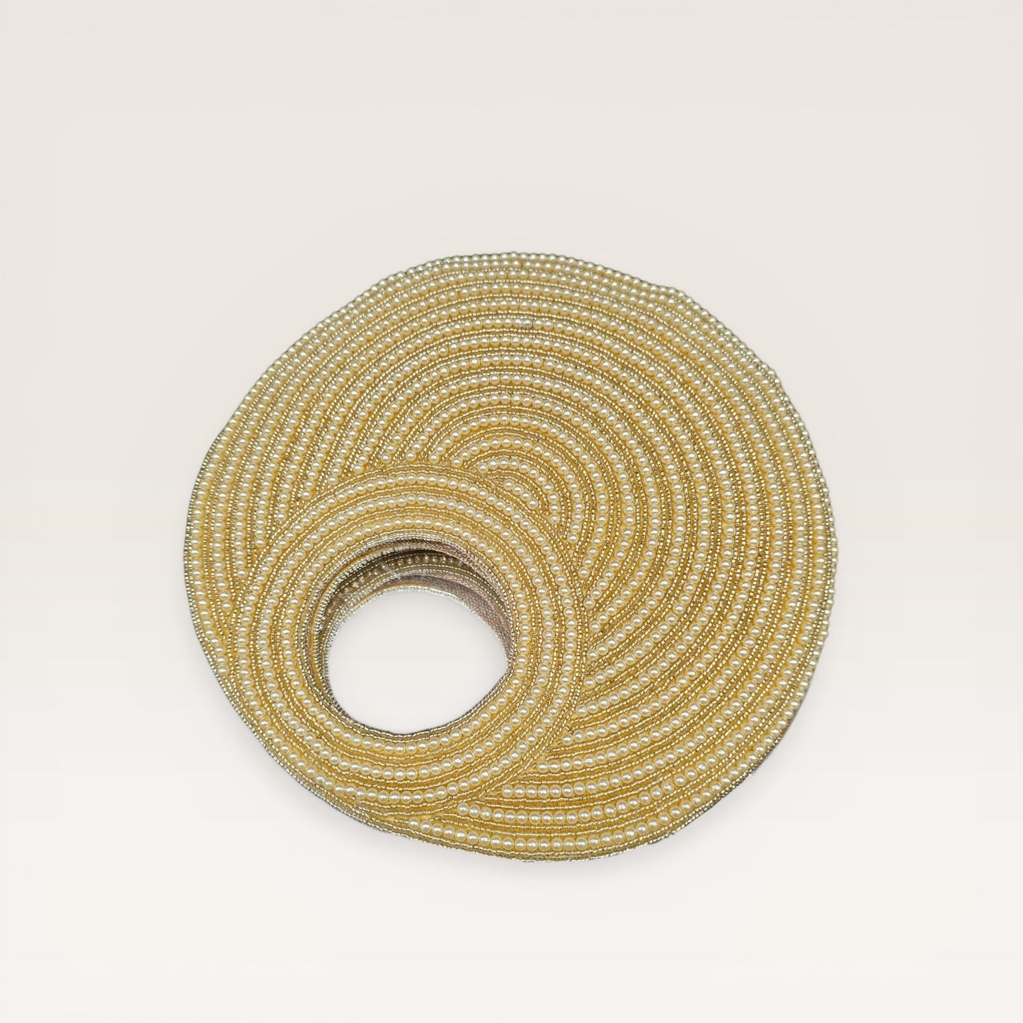Dual-sided hand-embroidered circular mother of pearl clutch featuring a central floral shell motif with diamond-cut crystal accents and premium seed pearls. This 8.5-inch slim-profile wedding bag is crafted on a natural jute base with a hidden magnetic closure, perfect for luxury bridal and ethnic festive wear