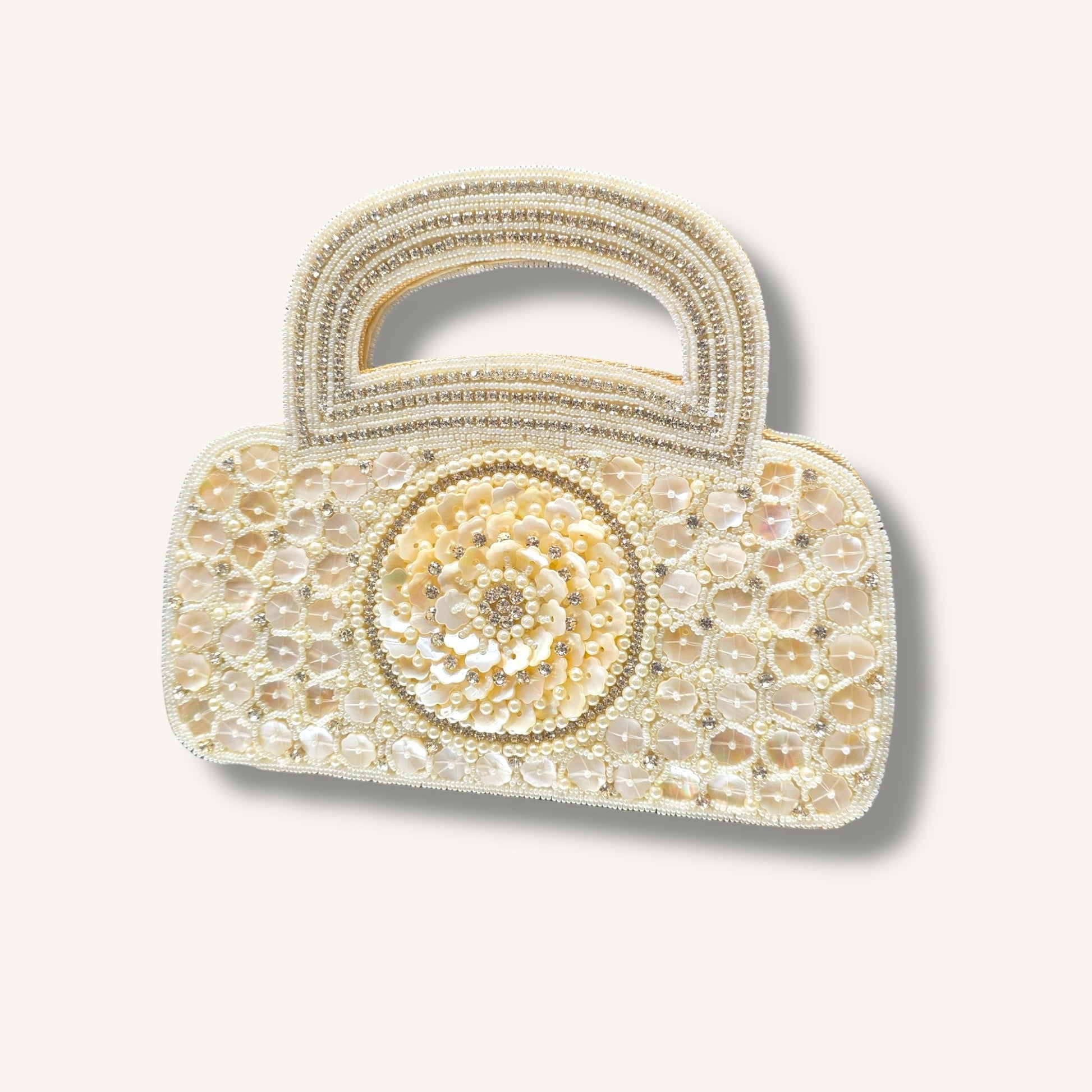 Dual-sided hand-embroidered luxury wedding bag featuring a central mother-of-pearl floral motif and a geometric pearl pattern on a natural jute base. This mini bucket-style bridal clutch includes a secure zip closure and an integrated hand-beaded handle, perfect for ethnic and festive wear