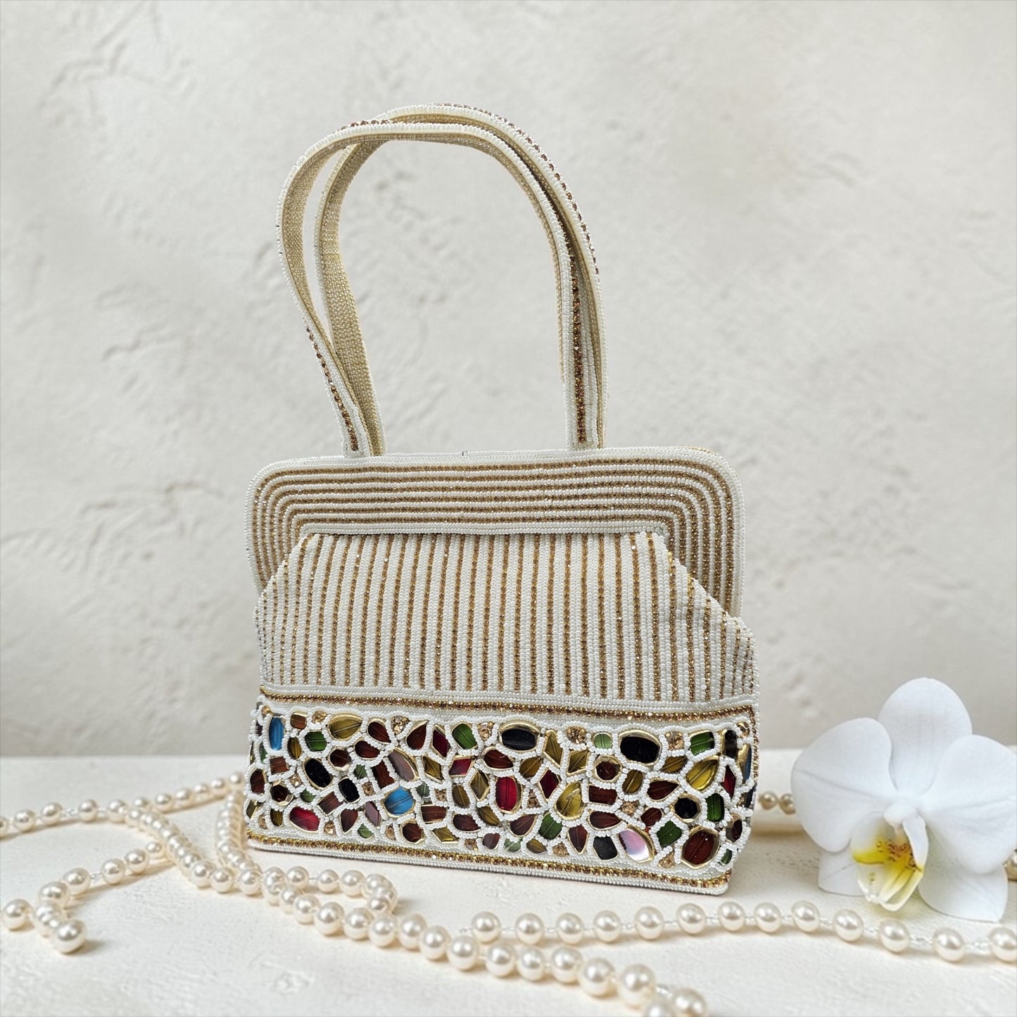 Hand-embroidered seed bead handbag with colorful stone border and twin embroidered handles.