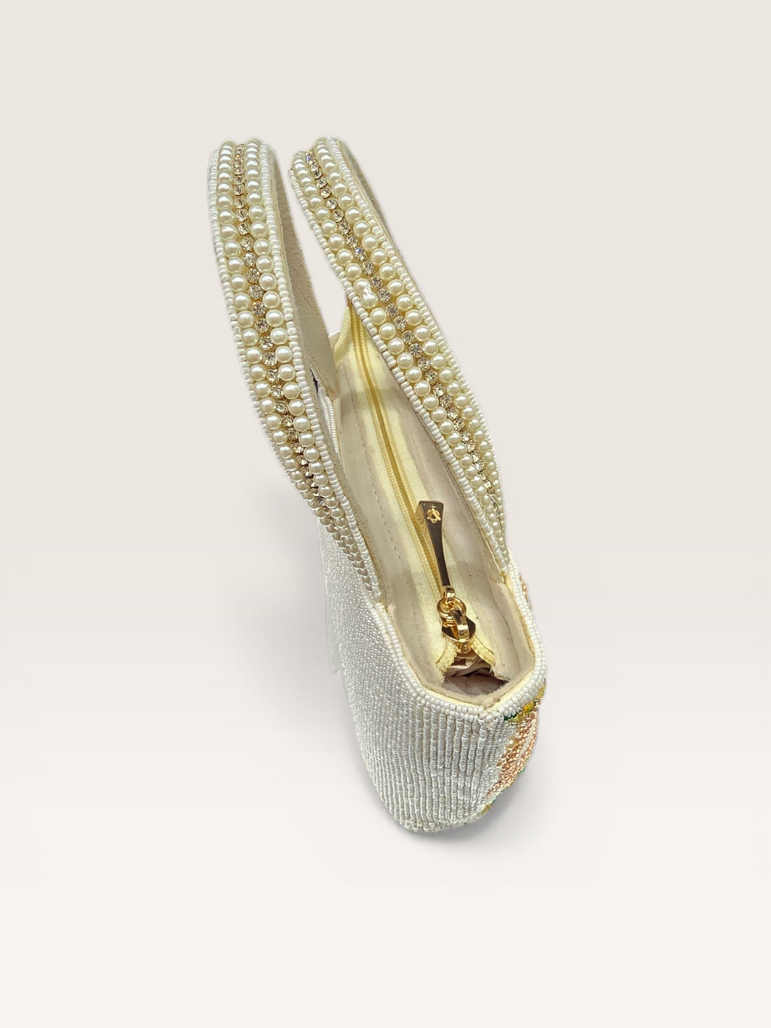 Hand-embroidered bucket bag with colorful floral beadwork and twin handles on a velvet base.