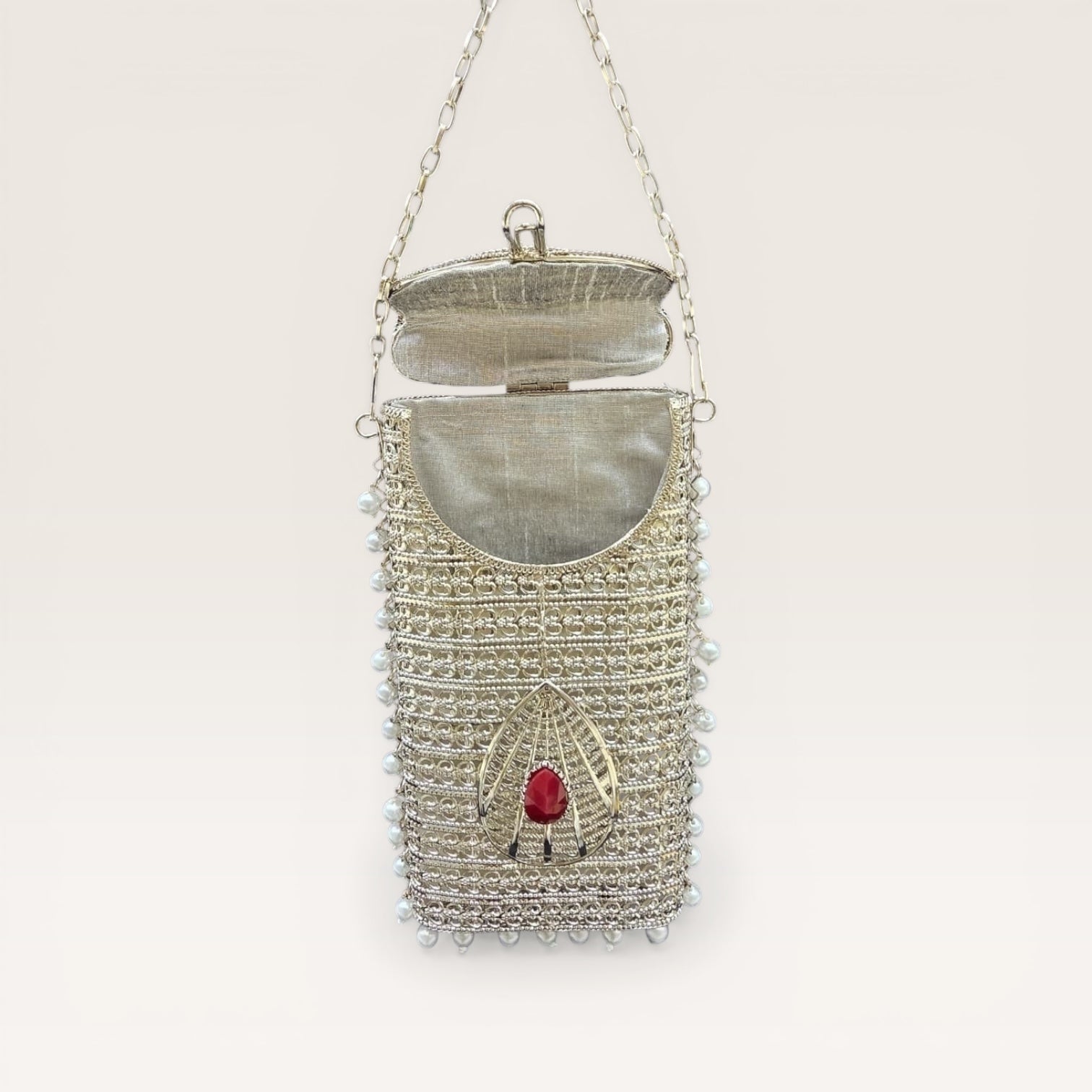 Designer brass phone clutch with pearl hangings and drop shaped stone detailing, ethnic party wear handbag
Premium Silver metal mobile bag with pearls and coloured stone accents, bridal clutch for women