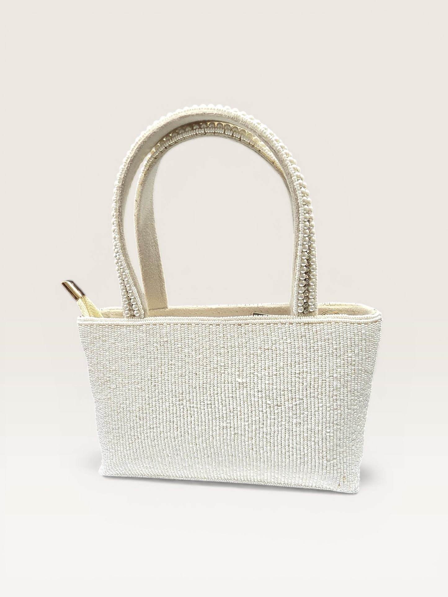 Hand-embroidered bucket bag with colorful floral beadwork and twin handles on a velvet base.