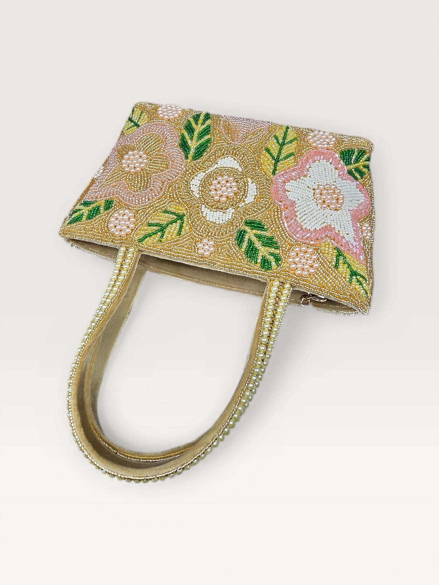 Hand-embroidered bucket bag with colorful floral beadwork and twin handles on a velvet base.
