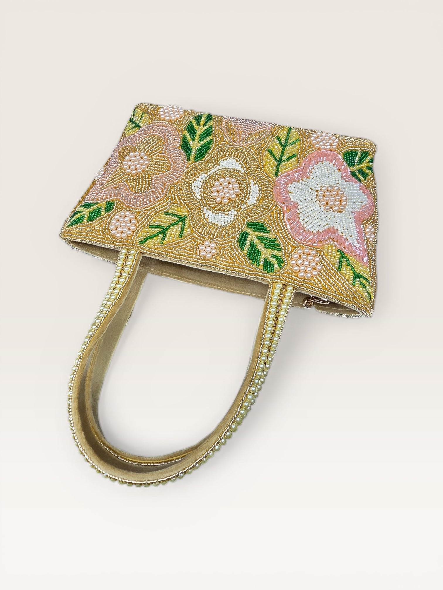 Hand-embroidered bucket bag with colorful floral beadwork and twin handles on a velvet base.